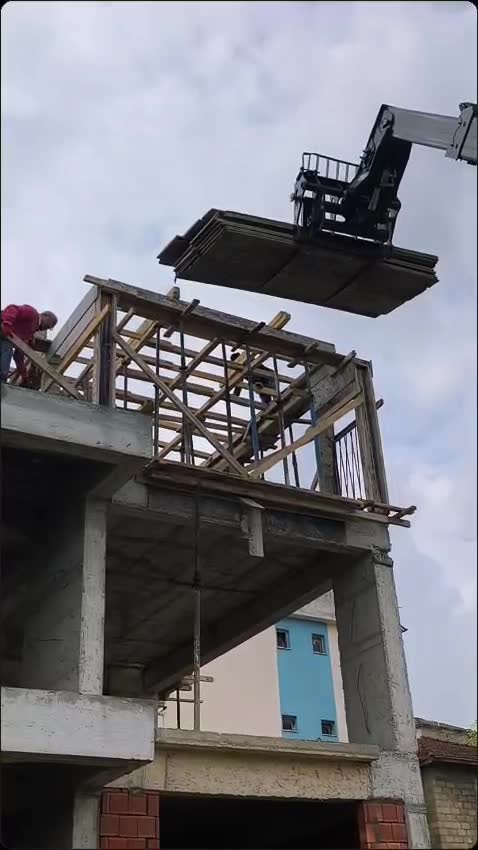 Manitou ile inşaat halindeki binanın çatısına kereste çıkarılması